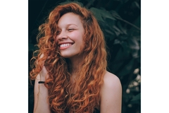 A woman with thick curly red hair.